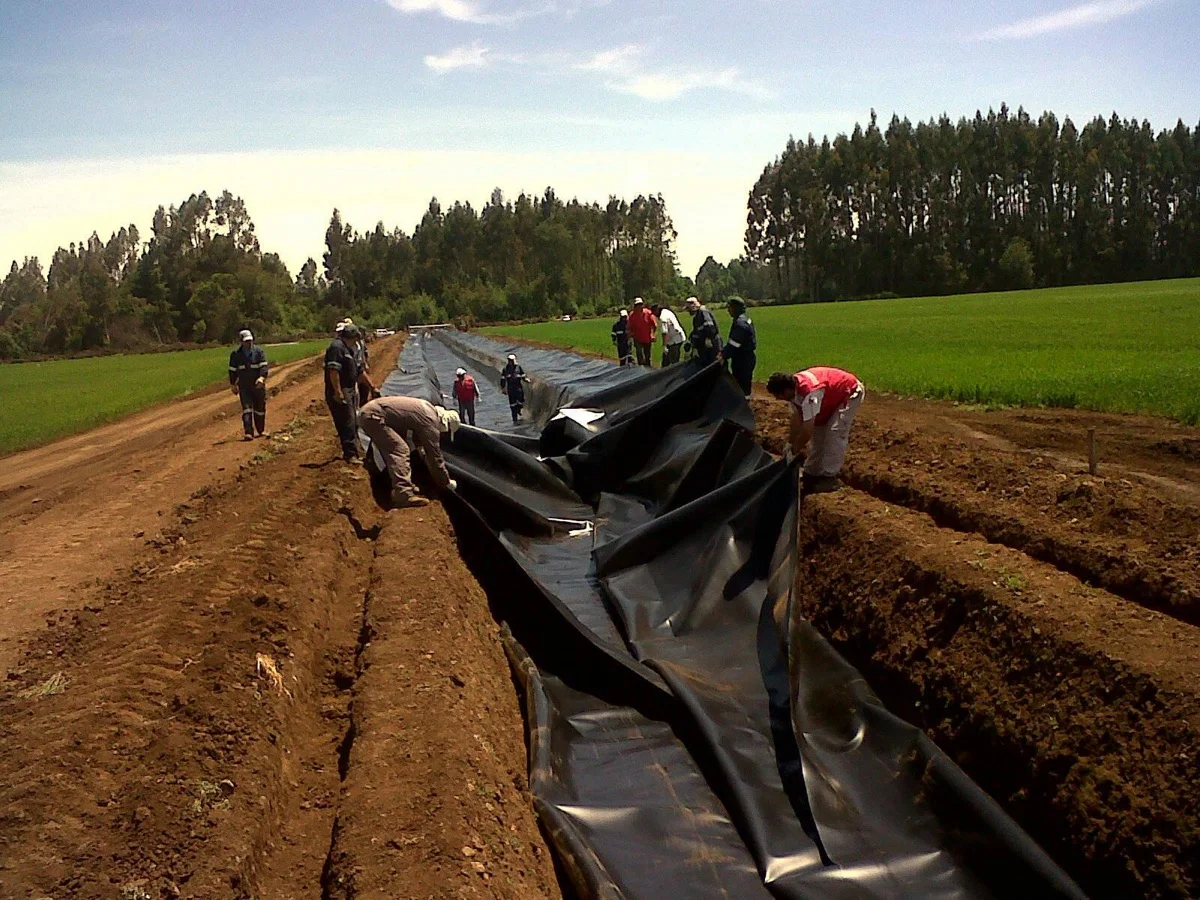 Cuadrilla instalando geomembrana en un canal de riego en Fundo Esperanza.